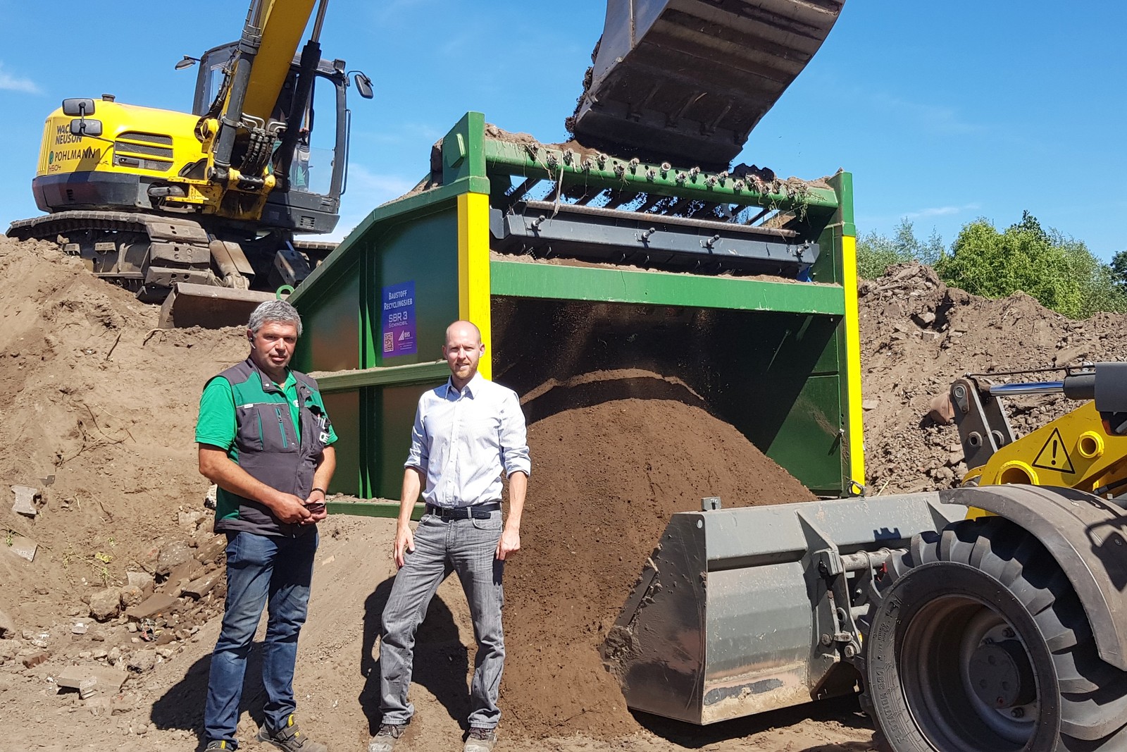 Geschäftsführer Ludger Pohlmann (l.) und Florian Schmellenkamp, BHS, vor dem Baustoff-Recyclingsieb SBR 3 sind zufrieden mit Siebleistung und Ergebnis.