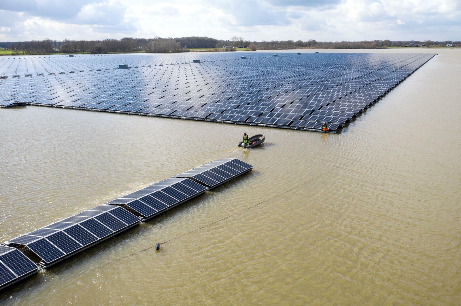 Bau einer Floating-PV-Anlage in Zwolle, Niederlande. Ein Schlauchboot zieht die Solarpanele zum Rest der Anlage. 